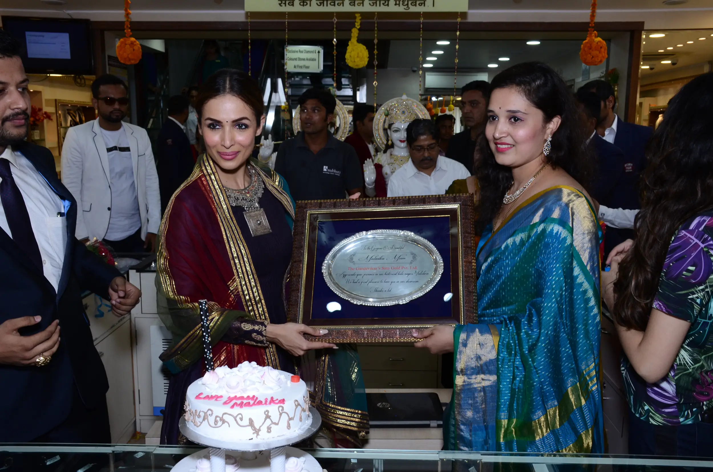 Group of men posing with large cartoon character inflatable figures at night outdoors